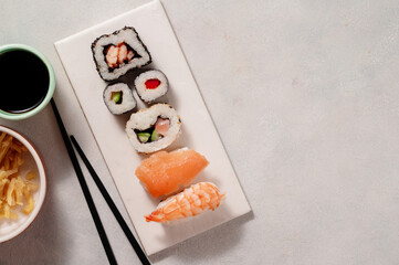 Homemade sushi rolls with salmon, shrimp, avocado. Served with soy sauce and ginger.