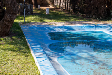 Blue blanket or tarpaulin to cover the pool and protect it from the elements or preserve the...