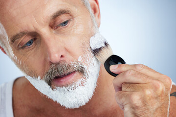 Man, beard and shaving cream for grooming, skincare or hair removal against a studio background....