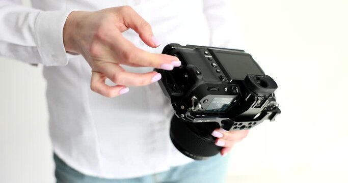 Photographer taking out memory card from black professional camera closeup 4k movie slow motion. Storing photos on electronic media concept