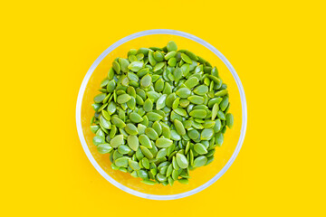 Seeds of leucaena leucocephala on yellow background.