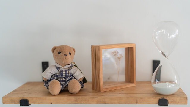 Teddy bears, picture frames and hourglasses on shelves.