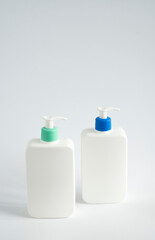 Two liquid containers for shampoo, gel, lotion, cream, bath foam etc. Blank unbranded cosmetic plastic bottles with dispenser pump.