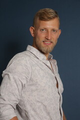 Obraz premium Blonde young man standing confident, portrait on studio background. Business, couch, office concept 