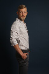 Fototapeta premium Blonde young man standing confident, portrait on studio background. Business, couch, office concept 