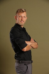 Blonde young man standing confident, portrait on studio background. Business, couch, office concept
