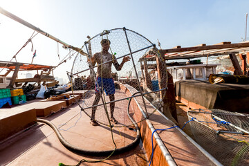 Fishman on fishing boat with fishing nets in Arab Emirates