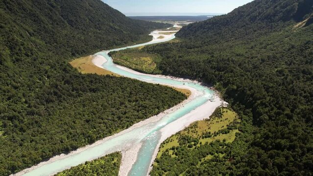 Confluence of two glacial rivers and wild nature scenery of Westland, New Zealand - aerial pull back landscape