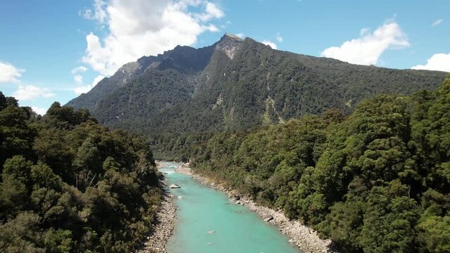 Pristine water of Copland river, native forest and mountain vista. Beautiful day in New Zealand, birds eye view.