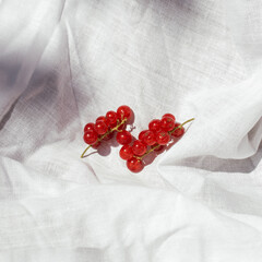 Red currants fruit and shadows against white rustic fabric. Natural sunlight.