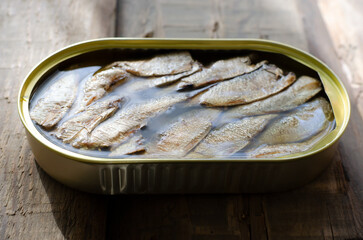 Canned fish on a wooden table. Tinned fish concept. Rustic style. Horizontal orientation.