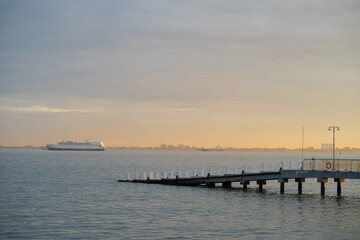 Obraz premium Modern concrete dock with cruise ship background during sunrise