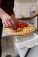 Woman recycling organic food waste into compost in a bokashi bin. Female person composting...