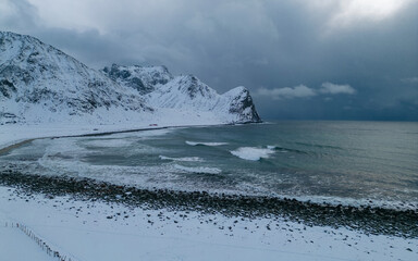 Stormy winter weather with high breaking waves - Unstad Beach Lofoten, Norway. The iconic spot in Arctic for winter surfing on waves of Norwegian sea and Atlantic ocean