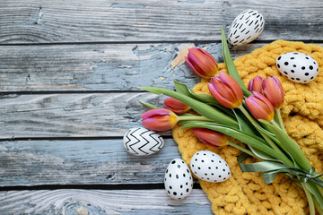 bouquet of tulips and easter eggs on a wooden background. easter layout. top view. copy space. flat lay. place for text