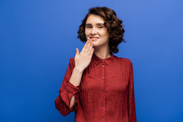 smiling teacher showing thank you gesture on sign language isolated on blue.