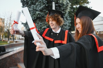 Portrait of two happy graduating students.