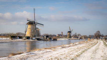 Piękna śnieżna zima w Niderlandach. Spokojny wiejski krajobraz z wiatrakami i kanałem.