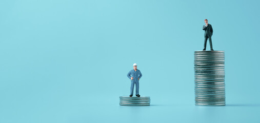 Different miniature businessman standing on different height coins stacking , Inequality income and...