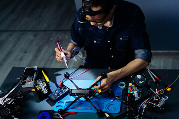 Engineer working on racing fpv drone combat kamikaze bomber in workshop.