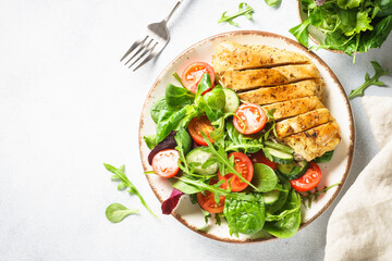 Healthy food plate on white. Green salad with roasted chicken fillet. Top view with copy space.