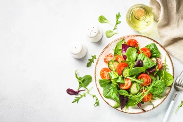 Foto op Aluminium Salad from green leaves and vegetables. Fresh green salad in white plate. Top view. © nadianb