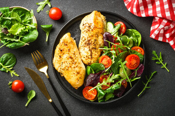 Fresh salad with chicken fillet and vegetables on black. Healthy food, keto diet.