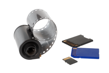 Micro SD card against vintage roll film in reel, on isolated background