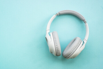 Wireless Headphones on blue background. Flat lay with copy space.