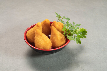 traditional fried coxinha in plate on slate background, popular brazilian snack
