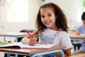 Learning, drawing and portrait of girl in classroom exam, education or studying with book. Preschool smile, development and happy kid or student coloring for creative art in notebook in kindergarten. - Powered by Adobe