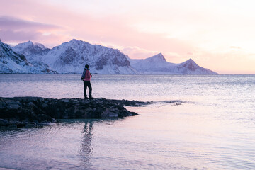 A traveler woman during sunset. Haukland Beach on Lofoten Islands, Norway. Journey and adventure. Winter landscape. Travel - image
