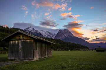 Fototapeta na wymiar Neighborhood of Garmisch Partenkirchen. View of the Zugspitze by sunset