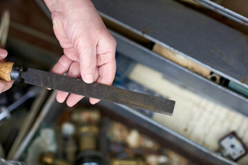 An elderly man is holding an old file in his hands