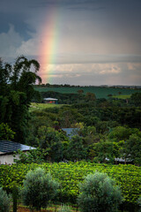 Proriedade rural no campo com arco-iris de fundo, sustentabilidade energia solar