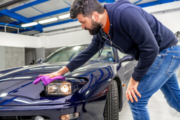 detailing and polishing the body of a luxury sports car using a micro fiber