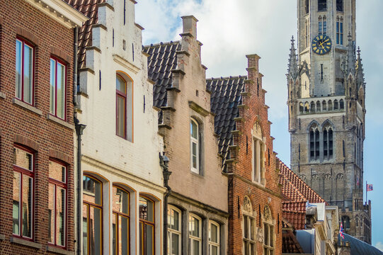 Typical examples of Flemish architecture in Bruges, Belgium. Brick houses. Belfry gothic tower in the background. © Xavier Allard