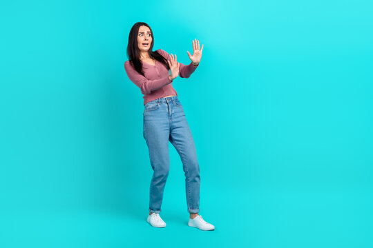 Full body size cadre of young unhappy angry woman hands show stop symbol scared nervous panic stop bad news isolated on cyan color background