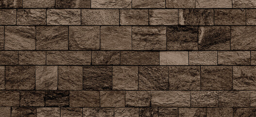 wide stone wall texture. Empty brown stone block wall background. cut stone surface