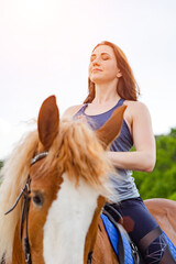 young woman doing yoga on a horse against the backdrop of trees