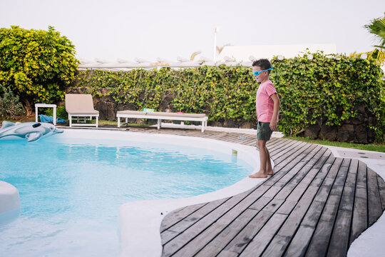 child ready to jump into the pool with clothes on