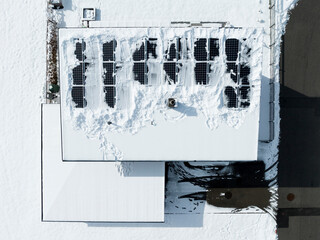 pent flat roof with snow freed photovoltaic panels in winter sunshine