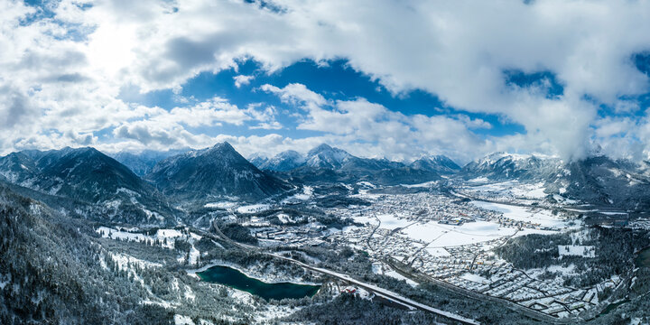 freshly snow-covered basin of reutte in spring with lake urisee and cloudy sky