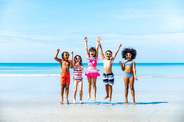 Group of Diversity little child boy and girl friends running and playing sea water at tropical beach together on summer vacation. Happy children kids enjoy and fun outdoor lifestyle on beach holiday.