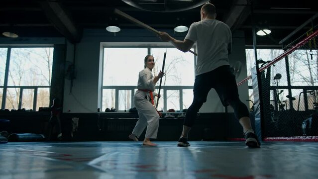 Two fighters practicing with a wooden sword in Aikido Sport and martial arts concept