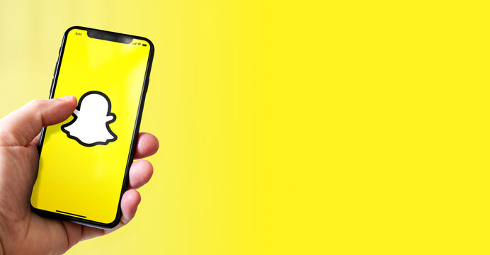 Hand holding iphone smartphone with Snapchat logo, Paris, France