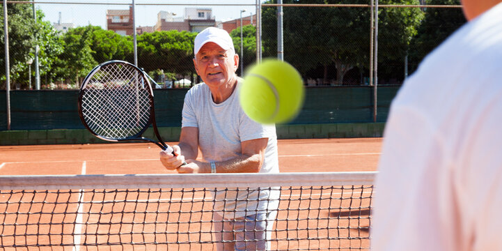 mature sportsman playing at tennis court