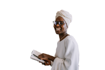 Cheerful African young woman in white turban, glasses and white dress holds diary, pen standing at home against transparent background looks at camera smiles. student female remote learning. Education