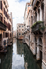 Fototapeta na wymiar Alte Häuser mit Säulenbalkon und Kanal in Venedig, Hochformat