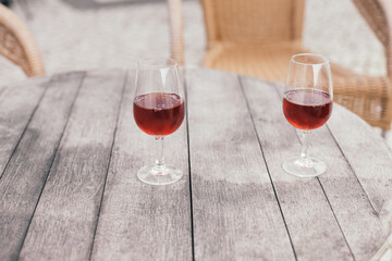 Two glasses of orange moscatel wine from Setubal on a wooden table on a terrace 